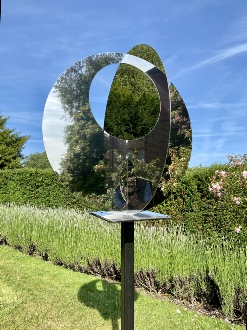 Spheres - a mirrored stainless steel scilpture - two intersecting discs with holes - reflections create an optical illusion