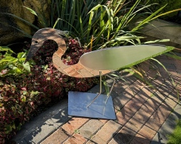 Stainless steel sculpture called "Poised to Strike" - a stylised grey heron bent over ready to catch its prey