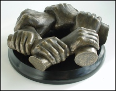 Life cast of a family group holding each others' wrists in a circle.